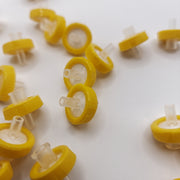 Group of yellow 13 mm nylon syringe filters with clear inlet and outlet connections
